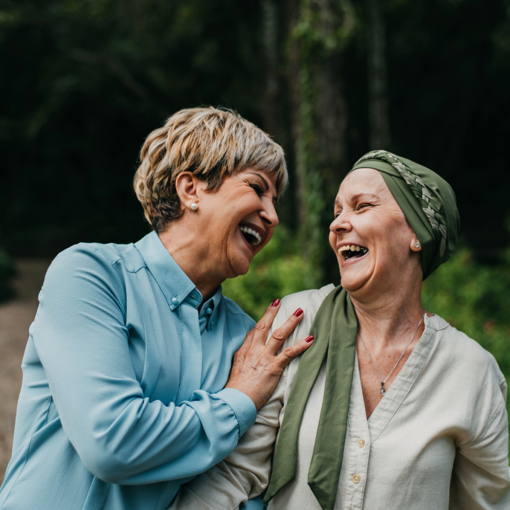 Two ladies laughing, one wearing a head scarf